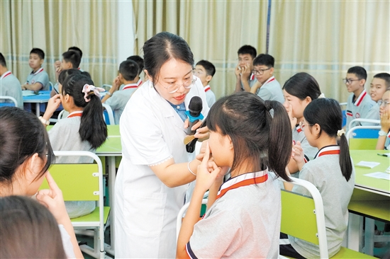 马玉莹教学生找穴位。 马玉莹教学生找穴位。