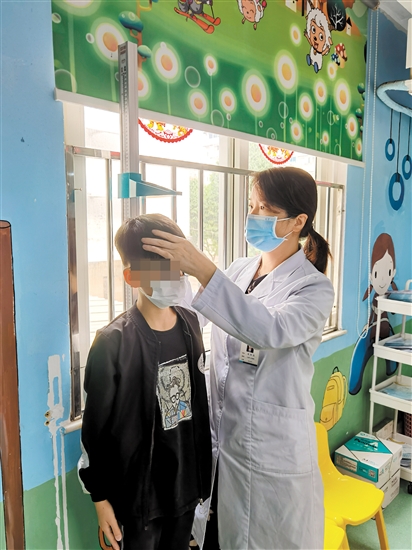 医生为儿童量身高。 医生为儿童量身高。