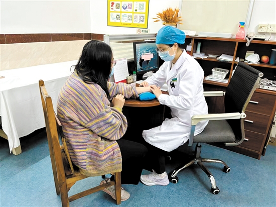 周春华向患者了解情况。