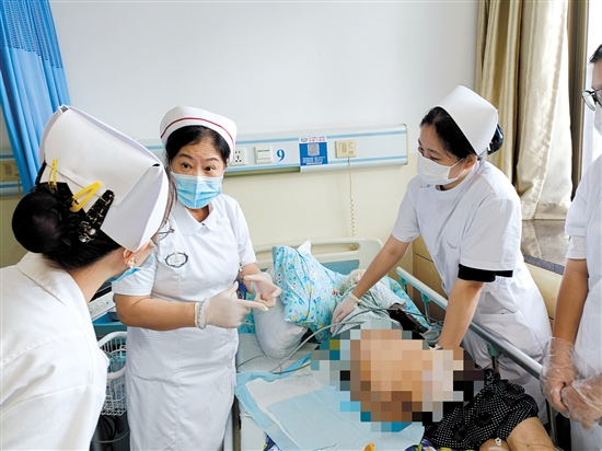 朱敏林（中）与同事对患者进行护理服务。