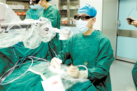 术中,医生查看显示屏,为患者植入人工耳蜗。 术中,医生查看显示屏,为患者植入人工耳蜗。