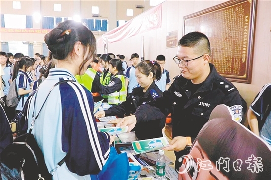 民警向学生发放安全知识宣传资料。
