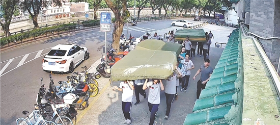 学生们抬着跳高垫奔赴现场。 学生们抬着跳高垫奔赴现场。