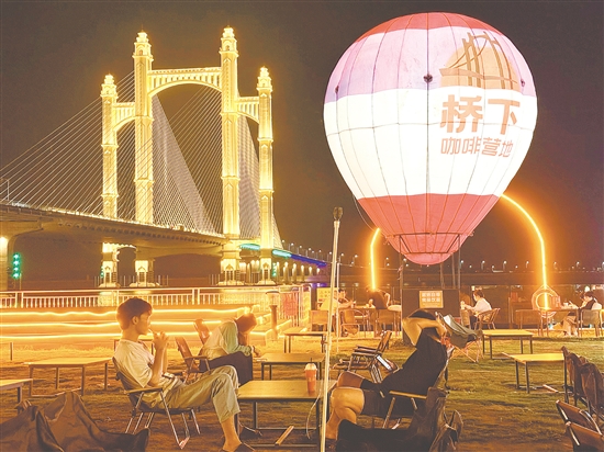 夜幕降临，潭江两岸灯火阑珊，市民、游客在“桥下咖啡营地”品咖啡、赏夜景，享受惬意时光。