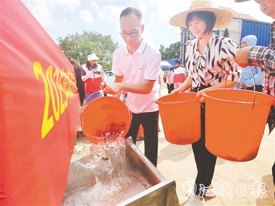 参与人员将鱼苗缓缓倒入放流槽。