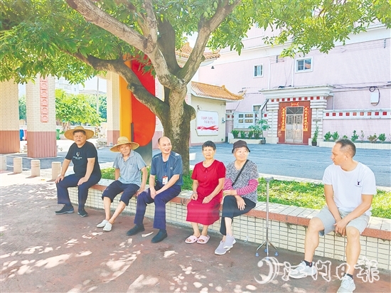 梁荣根（左三）与群众交流。