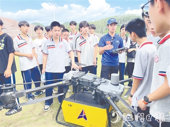 九年级学生向飞手了解无人机的操控技巧。