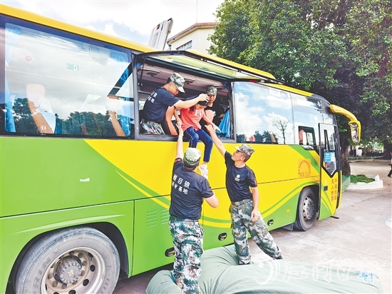 演练中，学生们在工作人员的帮助下体验逃生方式。