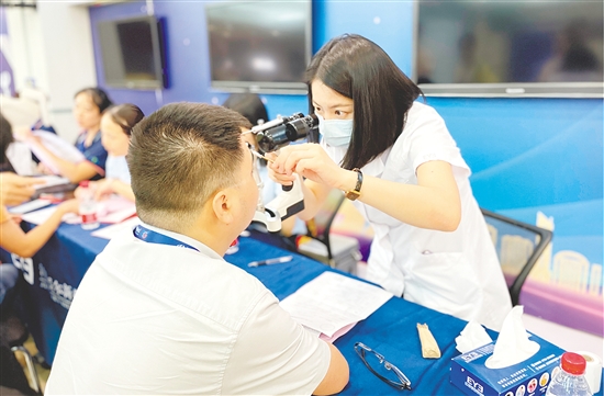 医护人员为企业职工检查眼睛。 医护人员为企业职工检查眼睛。