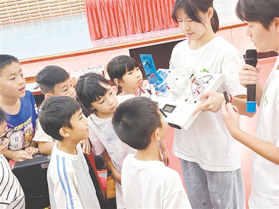 服务队队员向孩子们展示氢燃料电池演示仪。 服务队队员向孩子们展示氢燃料电池演示仪。