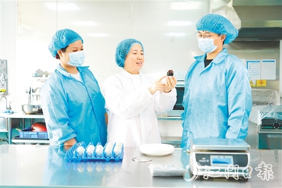 在培训室里，梁艳芬（中间白衣）和大家交流蛋品检测方式。