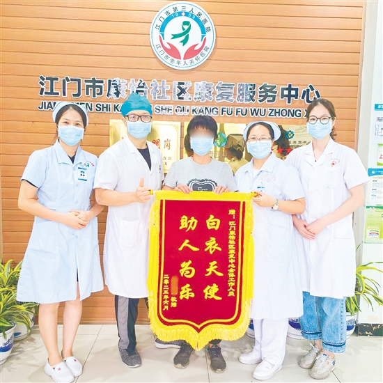 李明给康复中心医护人员送上锦旗。 李明给康复中心医护人员送上锦旗。