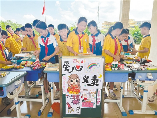 学生们穿梭在各摊位间“淘宝”，以实际行动奉献爱心。