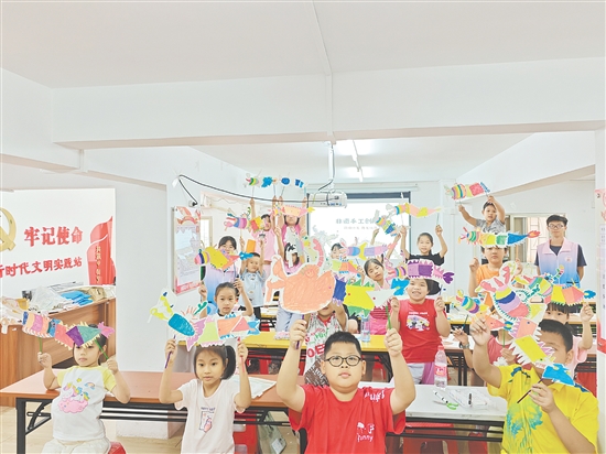 孩子们手持自制荷塘纱龙一起合照，课堂变民俗小舞台。