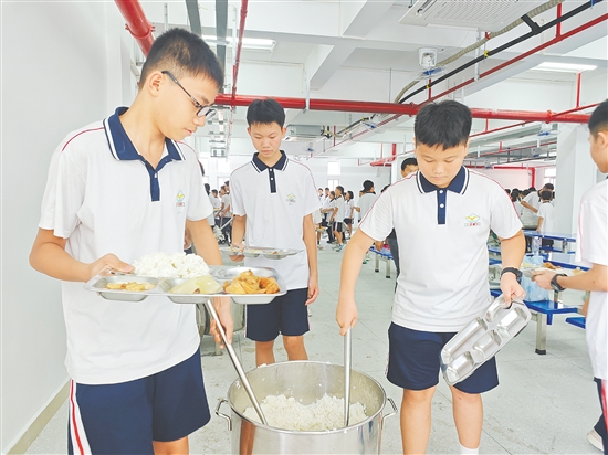 在鹤山一中附属中学,学生在崭新的饭堂有序打饭,该校精心设计菜谱,确保营养与美味兼备。 在鹤山一中附属中学,学生在崭新的饭堂有序打饭,该校精心设计菜谱,确保营养与美味兼备。