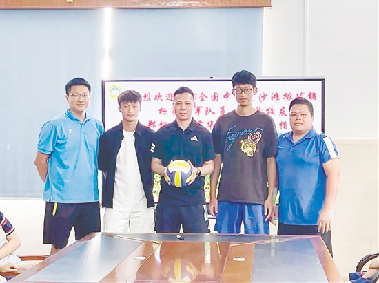 郑铭毅(左二)与谭华锋(右二)将亲笔签名的排球赠予母校。 郑铭毅(左二)与谭华锋(右二)将亲笔签名的排球赠予母校。