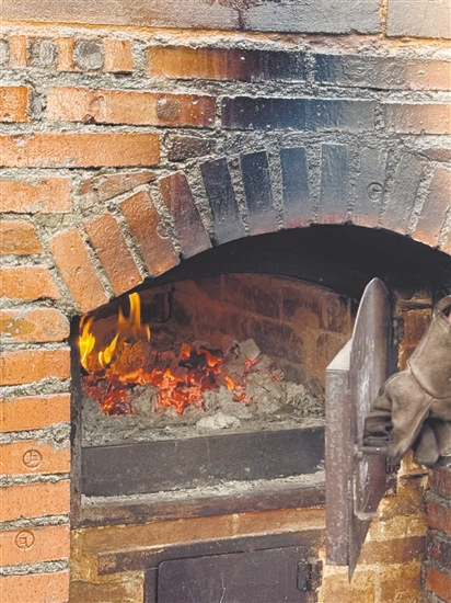 荔枝柴要烧两个多小时,窑炉温度到350℃以上才能烤面包。 荔枝柴要烧两个多小时,窑炉温度到350℃以上才能烤面包。