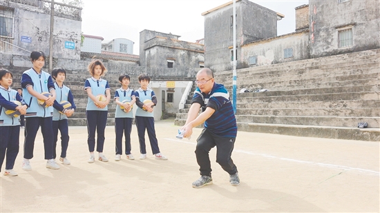 伍超明给孩子们演示垫球。 伍超明给孩子们演示垫球。