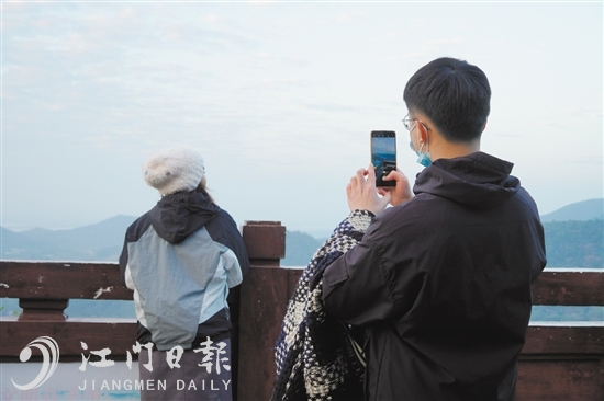 新年第一缕阳光升起之际，一位市民在圭峰山为女友拍照留念。