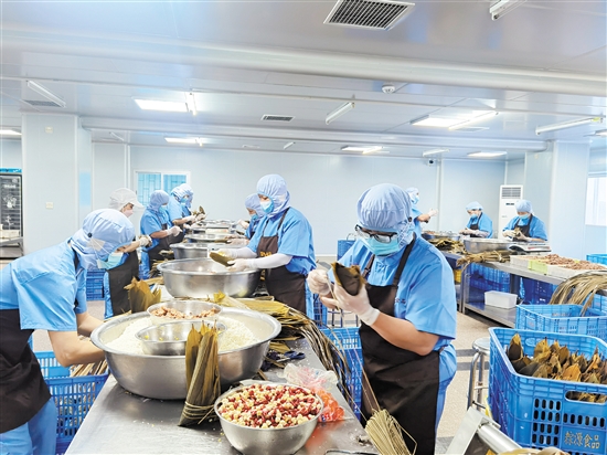 恩平市粽源食品有限公司生产的恩平裹粽供不应求，图为工人在忙着赶货。