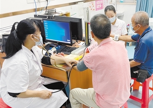 医生为退役军人量血压、看病历，解答健康问题。