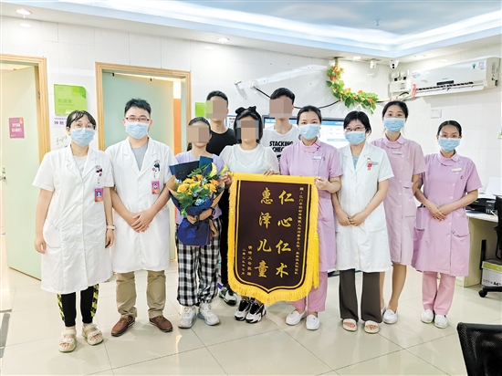 康复后，患儿和家属一起送上鲜花和锦旗致谢。