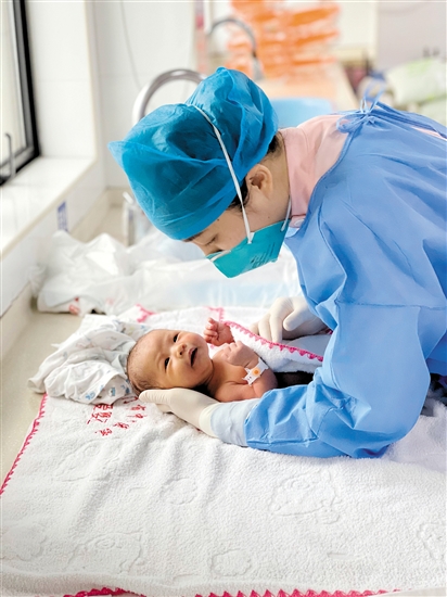 江门市中心医院医护人员为婴儿检查身体情况。