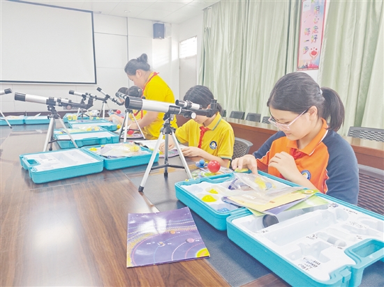 在“小小科学家”社团，学生们在教师的指导下学习天文望远镜的使用方法。