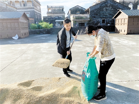 斗山镇横江村驻村第一书记李鹏举（左）帮村民收稻谷。