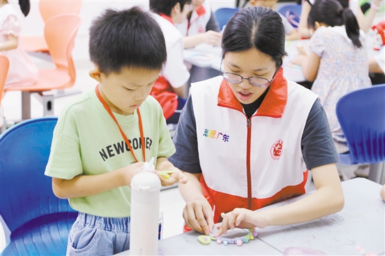 志愿者在教学生们制作京彩头饰扭扭棒。