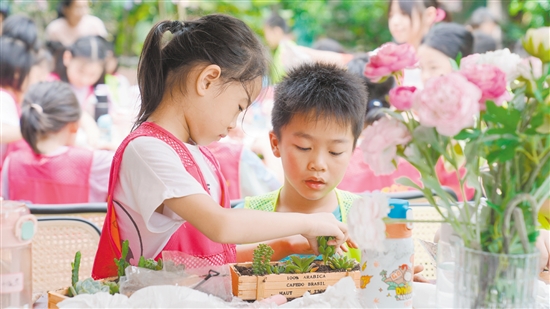 江门职工子女托管活动深受欢迎，但是“一位难求”。图为职工子女在上实践课，体验种植多肉植物。