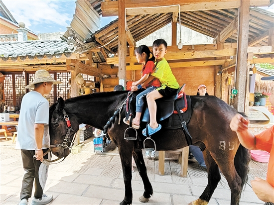 黄信诚（右一）在古道体验骑马。