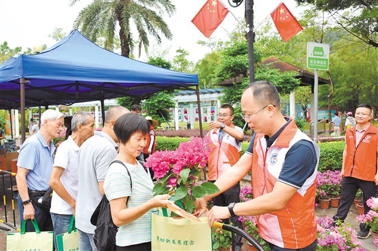 活动中，400盆簕杜鹃不到一小时便全部送出。图为市民排队领取市花。