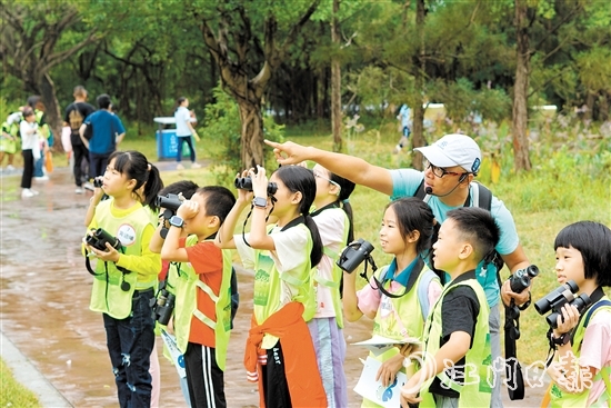 孩子们学习使用望远镜观鸟。