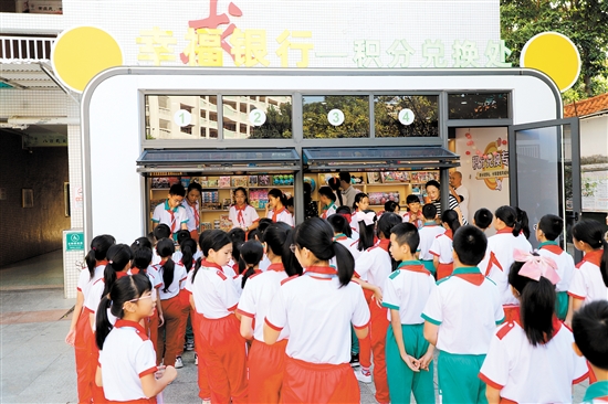 圭峰小学设立“幸福银行”，激励学生更好实现综合发展。图为学生们在用积分兑换礼品。