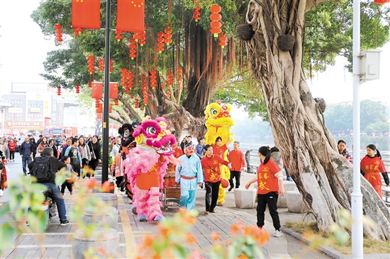 市民游客跟着醒狮一边巡游，一边观赏江门美景。