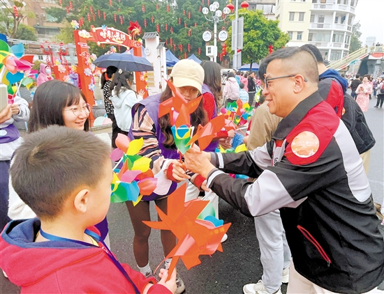 活动现场，市民积极参与捐款、义卖等活动，图为市民在购买丰泰小学师生制作的、用于义卖的风车。