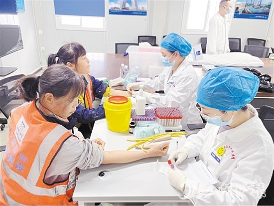 医护人员为工友进行身体检查。