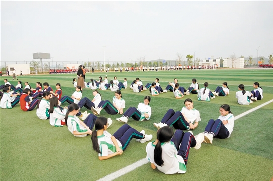 开平市风采实验学校通过统筹师资和场地资源，保证学生每天的锻炼时长。