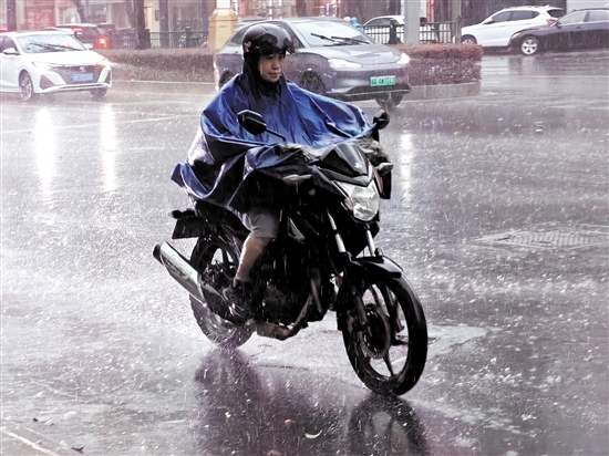 昨天，在市区东华一路，一位市民骑着摩托车在雨中前行。