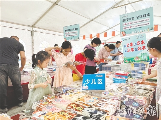 全民阅读图书文化活动中，大人小孩共享阅读乐趣。