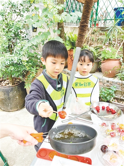 孩子们用自己采收的甘蔗熬糖水制作糖葫芦，感受劳动的乐趣。
