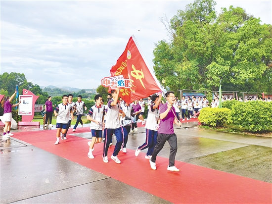 在台山市武溪中学，老师挥舞着“中考加油”的红旗为考生加油助威。