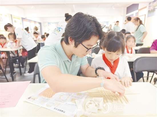 学生志愿者耐心教导孩子制作手工。 学生志愿者耐心教导孩子制作手工。