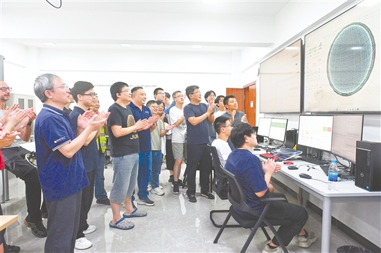 8月26日，科研人员在江门中微子实验运行控制室共同开启物理取数，鼓掌庆祝取数成功。