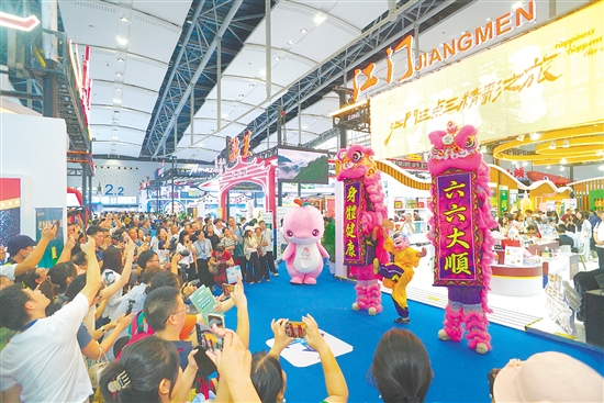 江门展馆内，醒狮腾跃的精彩表演引得参观者纷纷举起手机，定格这热闹瞬间。