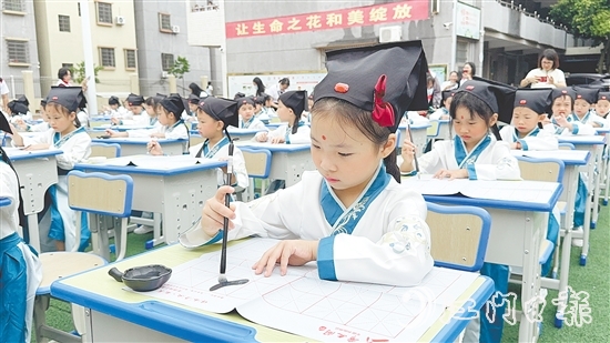 学生们在老师指导下认真书写“人”字。