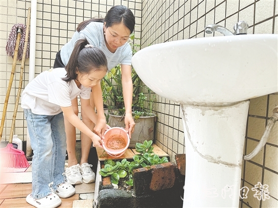 学生和家长一起清理家中积水。