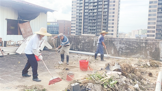 石田村“银发行动队”队员在清理房顶垃圾。谌磊 石田村“银发行动队”队员在清理房顶垃圾。谌磊