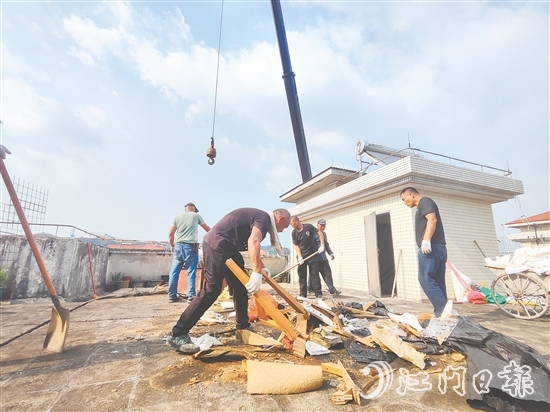 志愿者上门清理居民楼天台的垃圾。